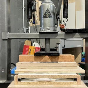 A shop press with the 3P triangle logo, set up over a plywood mold form