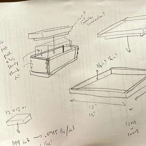 Hand-drawn sketch of a mold box with dimensions and material volume calculations