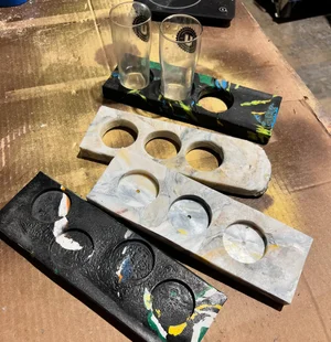 Four finished shot-glass holders molded from marbled recycled plastic