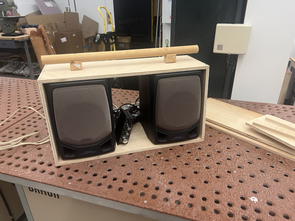 Both salvaged speakers mounted in the plywood enclosure with the dowel handle attached on top