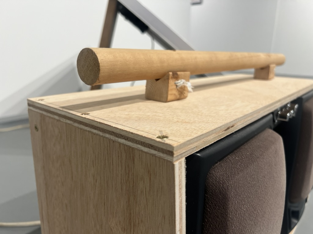 Close-up of the dowel handle, joined to the enclosure with two small wood blocks